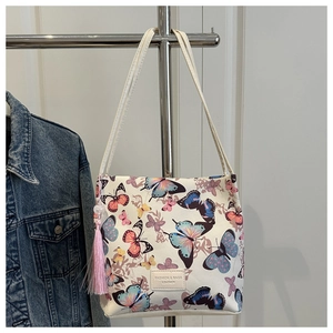 Detail van vlinderprint bucket bag met roze zijden kwastje en leren merkpatch