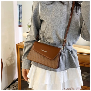 Detail of small square crossbody bag featuring brown leather and woven texture mix