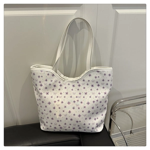 Détail du sac cabas floral avec motifs de fleurs violettes et anses en cuir PU blanc