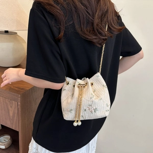 Sac seau tissé chic avec broderie florale et cordon de perles porté à l'épaule