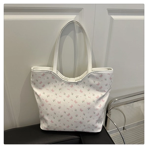 Détail du sac cabas en toile montrant des imprimés tulipes roses et papillons doux