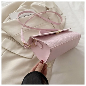 Detail shot of pink woven texture leather crossbody bag with gold metal hardware buckle
