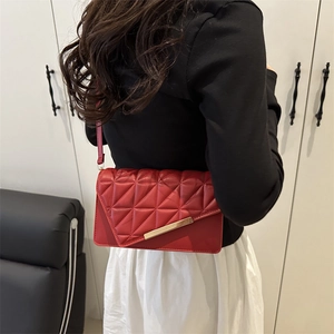 Elegant red quilted leather crossbody bag with gold metal trim and adjustable strap