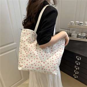 Sac cabas en toile blanche avec motif cerises rouges et larges bandoulières sur mannequin