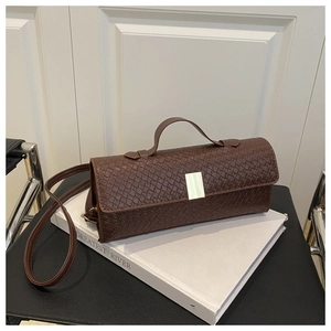 Detailed macro view of deep brown woven PU leather texture and gold metal buckle