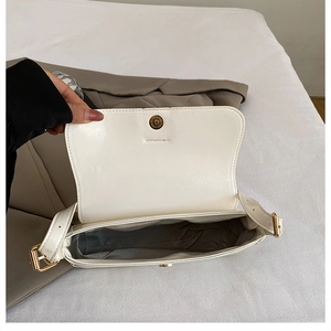 Detailed top view of white PU leather shoulder bag interior with golden magnetic clasp