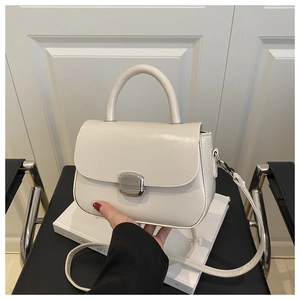 Detail of cream white leather mini square bag with vintage silver metal clasp and top handle