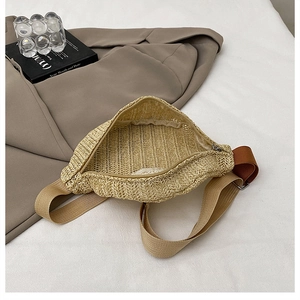 Détail du sac ceinture en paille tressée avec bandoulière réglable et intérieur zippé