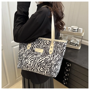 Zebra print tote bag worn over the shoulder showing the large capacity and stylish texture