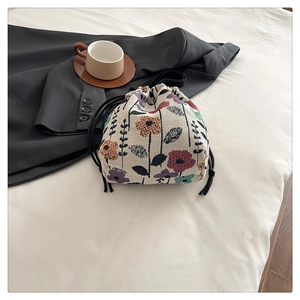 Close-up of a floral jacquard bucket bag with colorful patterns and black drawstring