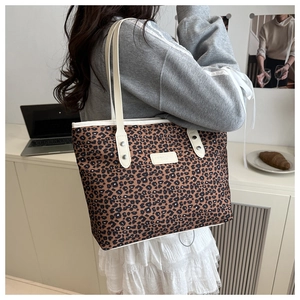 Close-up of leopard print tote bag with reinforced handles and brand patch detail