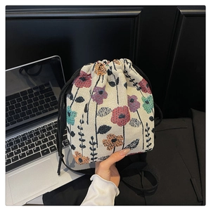 Detailed close-up of vintage floral jacquard bucket bag with black drawstring closure