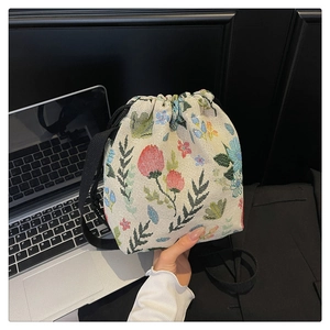 Detailed view of the vintage jacquard floral fabric and drawstring on the bucket bag