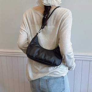Sac à bandoulière demi-lune noir minimaliste avec texture cuir et boucles argentées