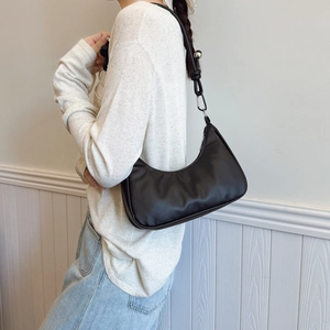 Sac hobo minimaliste noir avec perle argentée et texture en cuir synthétique lisse
