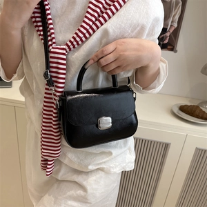 Fashionable black patent leather crossbody handbag with silver metal buckle closure