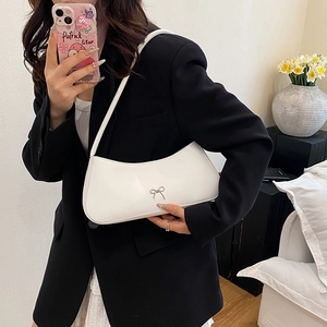 Minimalist white shoulder bag with silver bow accent in a stylish mirror selfie
