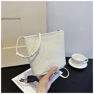 Detail of white woven texture on a minimalist bucket bag with matching handle