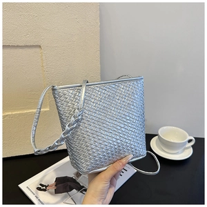 Detailed macro view of the silver woven texture and PU leather on this stylish bucket bag