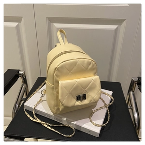 Macro shot of beige quilted faux leather backpack with silver turn-lock and chain strap