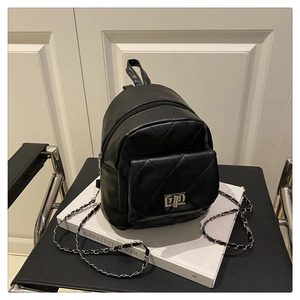 Detail of black quilted mini backpack featuring metal chain straps and twist-lock pocket