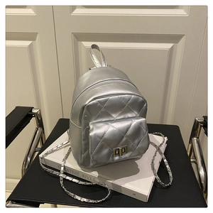 Detail of silver metallic quilted mini backpack with chain strap and metal turn-lock