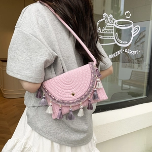 Pink woven saddle bag with purple tassels and ethnic style fringe, crossbody view