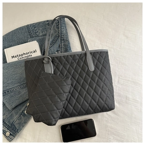 Gros plan du sac cabas matelassé noir avec porte-monnaie assorti et accessoires de mode