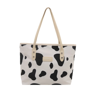 Cow print large tote bag with beige leather handles and fashion brand label for women