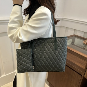 Sac fourre-tout matelassé vert élégant avec pochette assortie porté par un mannequin