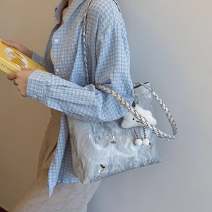 Silver wrinkled tote bag with butterfly ornament and woven strap for casual style
