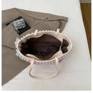 Détail du sac à main rose avec bordure en dentelle blanche et fermeture éclair en métal