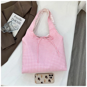 Detail of floral lining and ribbon tie on a reversible pink checkered canvas tote bag