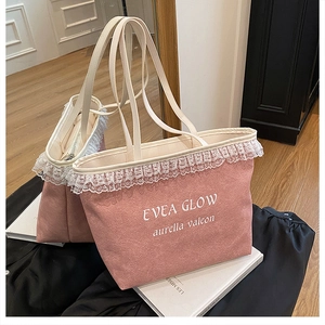 Détail du sac cabas en toile rose avec bordure en dentelle blanche et typographie