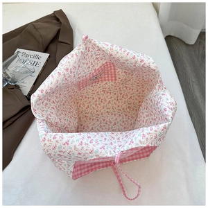Detail of floral tote bag showing double-sided design with pink plaid inner pocket
