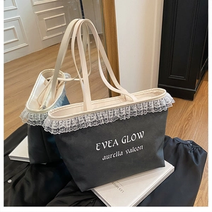 Détail de la bordure en dentelle et du logo imprimé sur le sac cabas en tissu gris