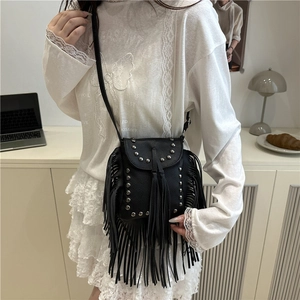 Bohemian black crossbody bag with silver studs and long leather tassels worn by model