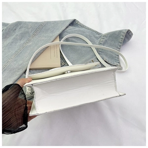 Internal view of a minimalist white bow shoulder bag with magnetic metal clasp