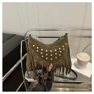 Detail of khaki suede crossbody bag featuring gold studs and long fringe accents