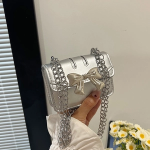 Mini silver crossbody bag for girls with metallic bow decoration and chain strap