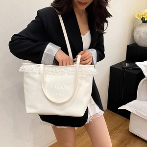 Sac fourre-tout chic blanc crème avec dentelle et imprimé DEA GLOW porté à l'épaule