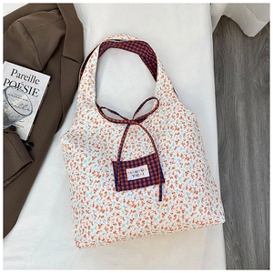 Detail of floral tote bag with contrasting plaid inner lining and small front pocket