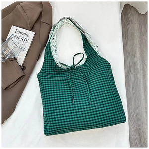 Close-up of green checkerboard tote bag with floral strap lining and tie closure