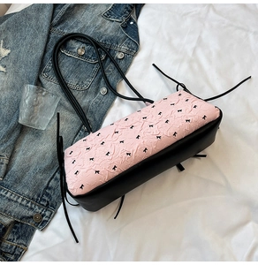 Detail der süßen rosa Plissee-Tasche mit schwarzen Minischleifen und Lederriemen