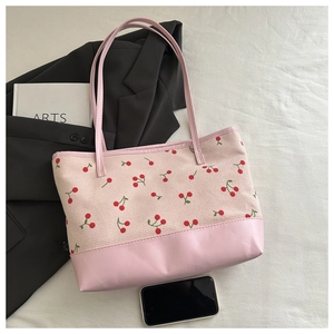 Détail du sac cabas en velours côtelé cerise avec base et anses en cuir rose