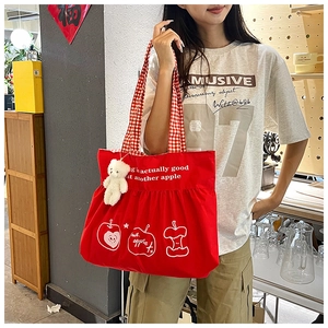 Red canvas tote bag with apple print, red checkered handles and teddy bear pendant