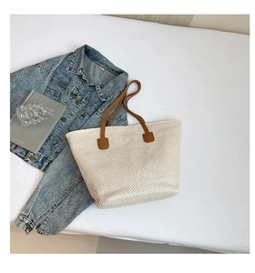 Vue à plat du grand sac cabas en paille avec lanières en cuir marron et style été
