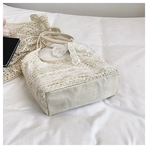 Gros plan détaillé des motifs de dentelle florale blanche et de la base en toile du sac