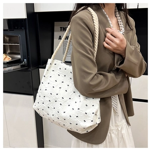 White quilted tote bag with black bow prints and rustic hemp rope handle detail