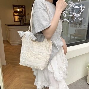Sac fourre-tout élégant en dentelle blanche avec grand nœud porté par un mannequin